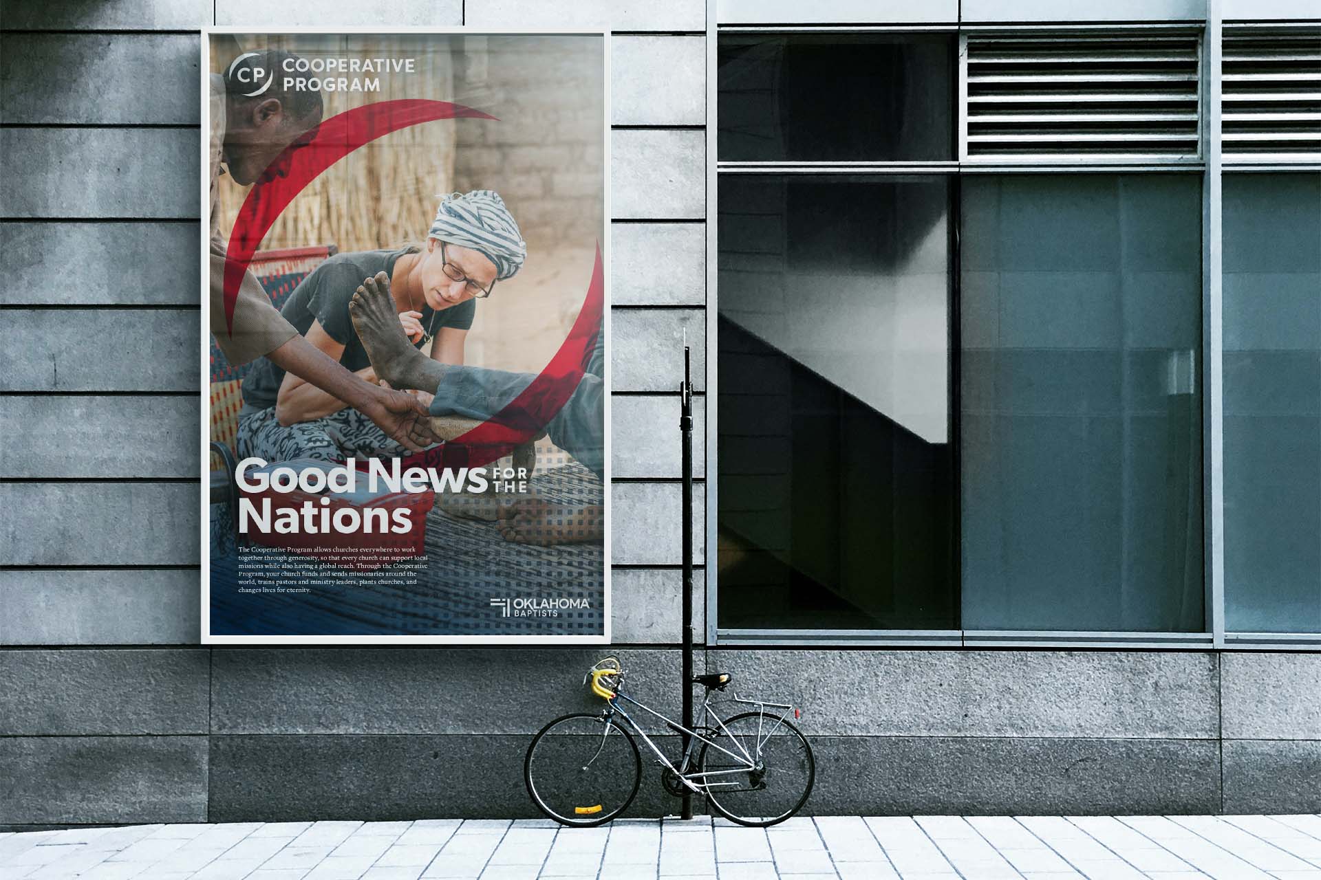 A poster mounted to the side of a building, depicting a missionary doctor examining a patient.