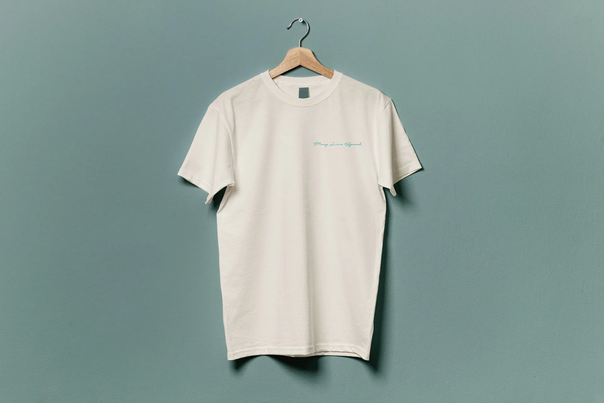 The t-shirt for this youth retreat, suspended on a wooden hanger against a teal background